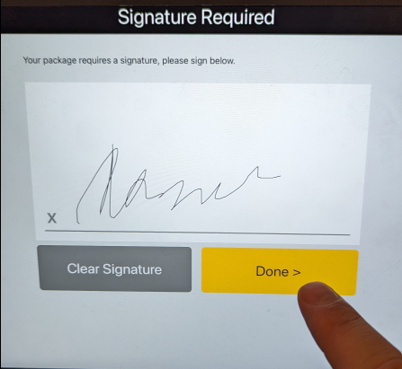 A finger pointing at a signature on a screenDescription automatically generated